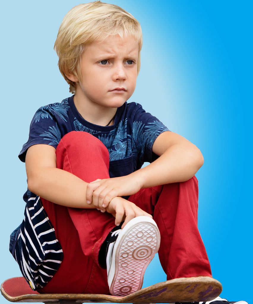 Photo of a boy sitting on a skateboard
