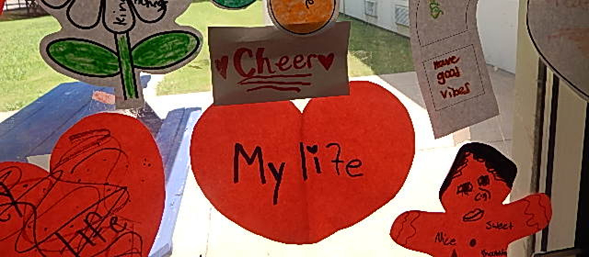 Paper cut-out shapes taped to a window